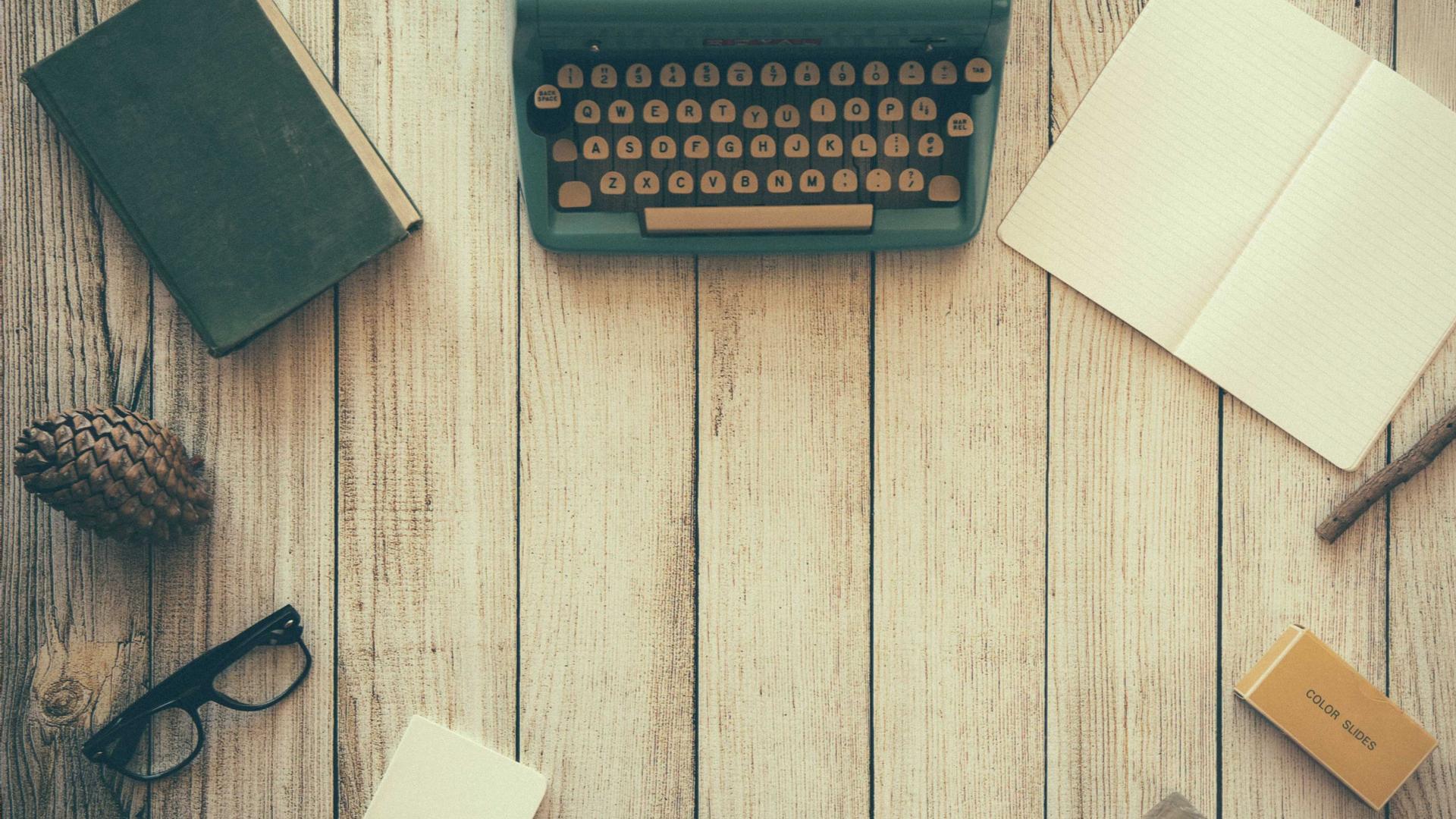 Editorial context photo of a typewriter and writing materials