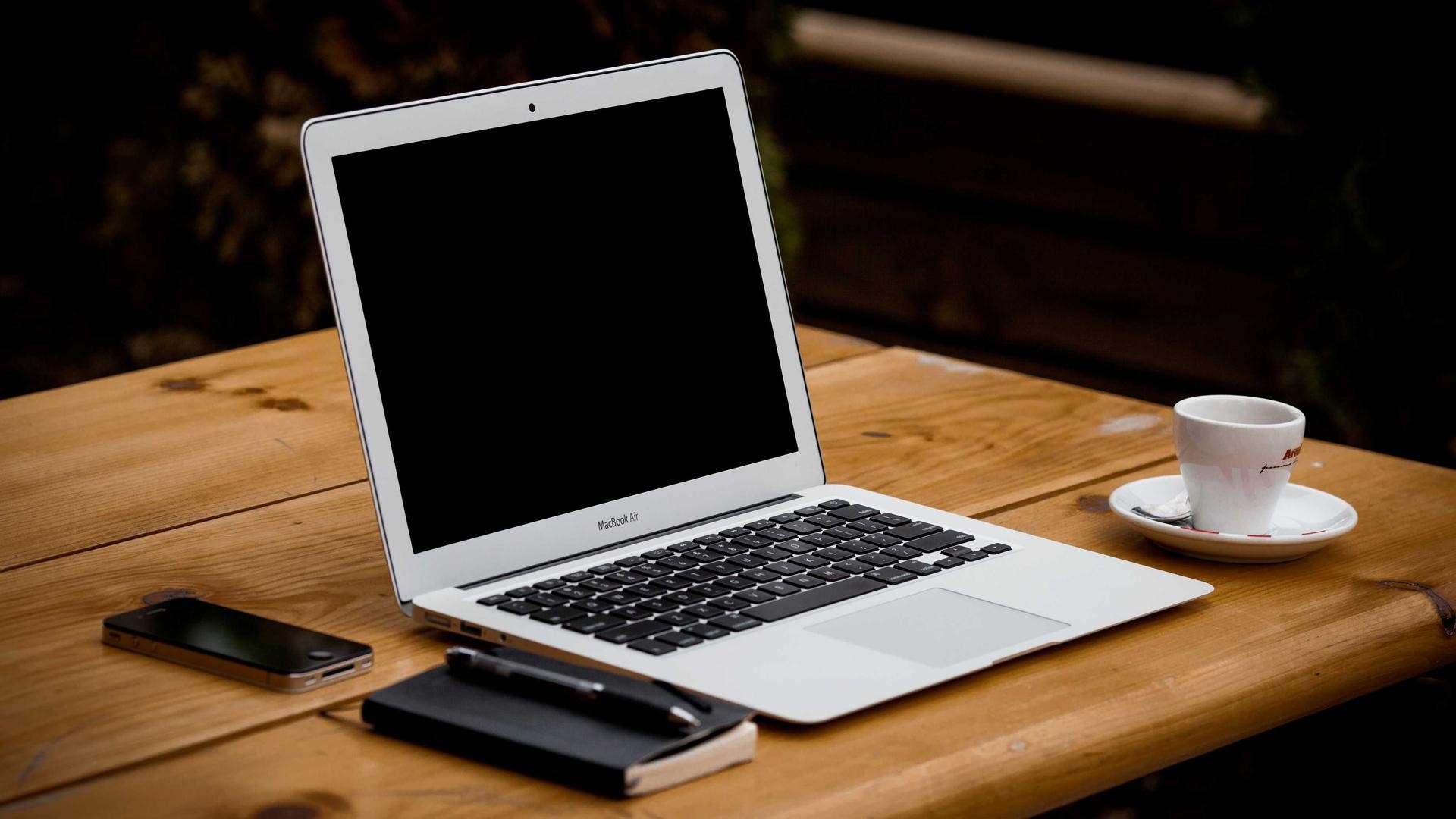 Editorial photograph of a laptop on a dark wooden desk